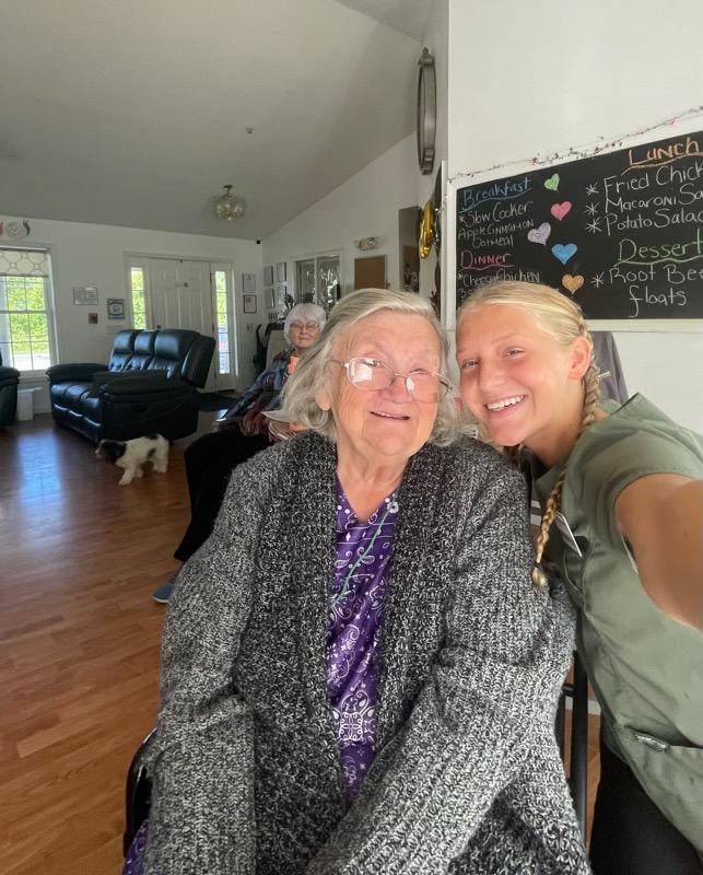 A woman and an older woman smiling together while taking a selfie