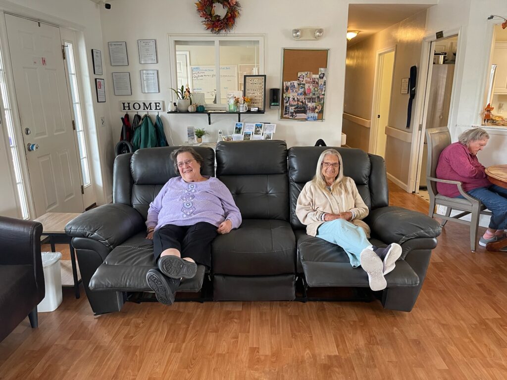 Two women comfortably sitting on a couch in a living room