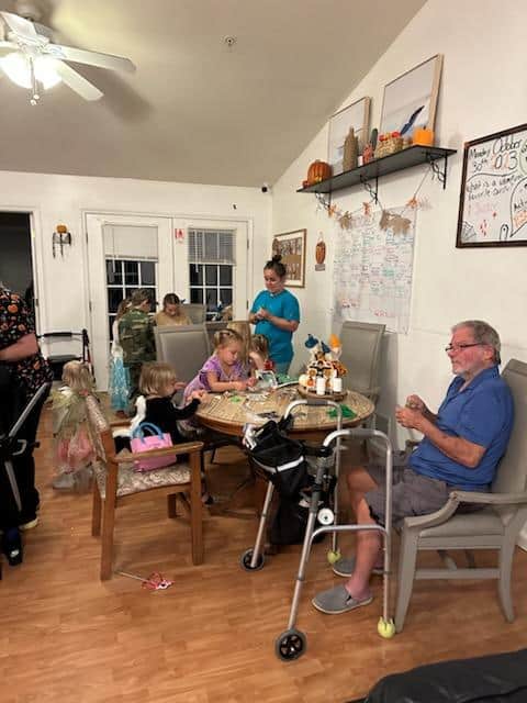 A family sits together at a table in a cozy living room